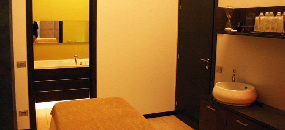 Cabina con lettino e lavabo, vista sul bagno
