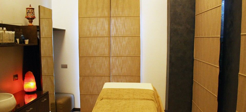 Cabina con lettino, lampada di sale e armadi in legno