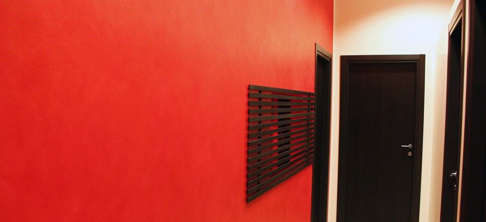 Corridoio con parete rossa e porte scure
